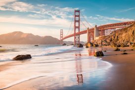 The Golden Gate Bridge at sunset with water and rocks. If you need representation for your discrimination case, contact the San Francisco discrimination lawyers at The Law Office of Jeannette Vaccaro.