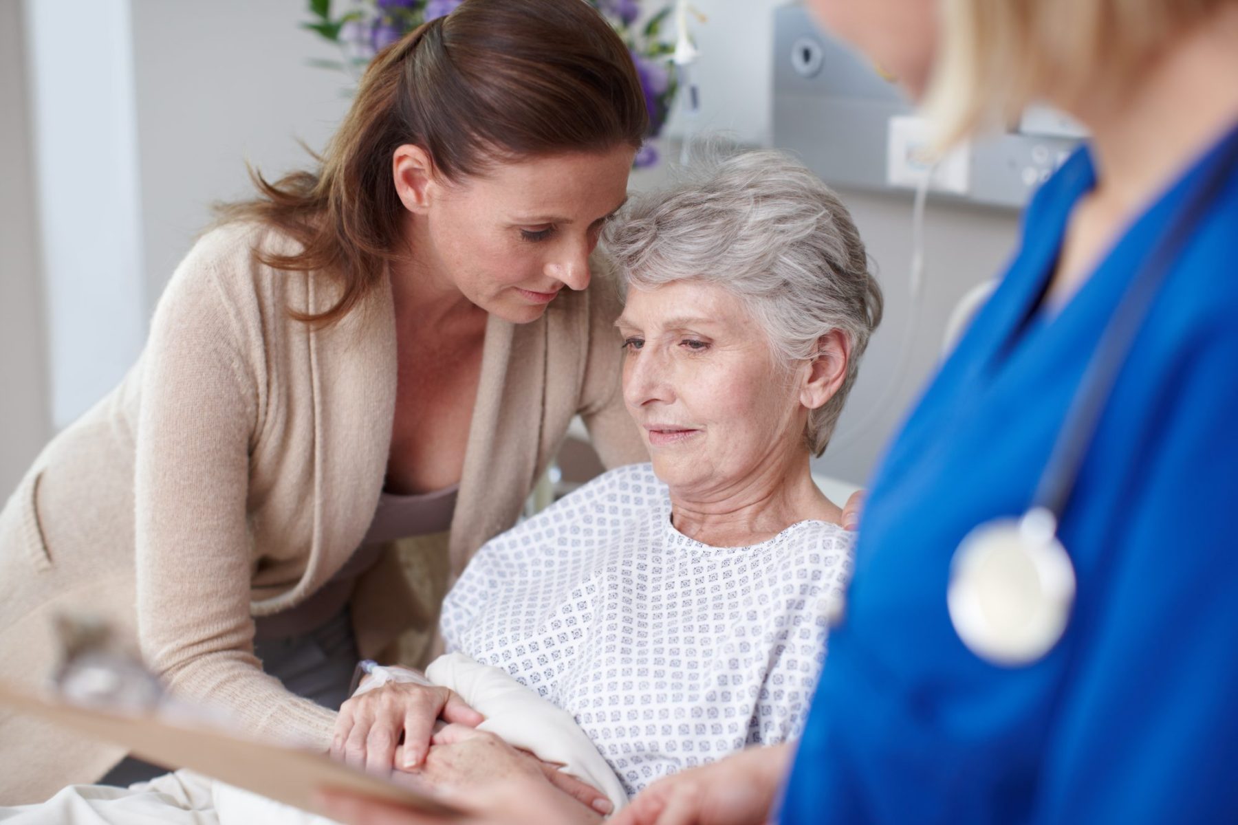 Woman comforting her mother in hospital, to show caring for parent and needing medical leave from job and needing Mountain View FMLA Attorney